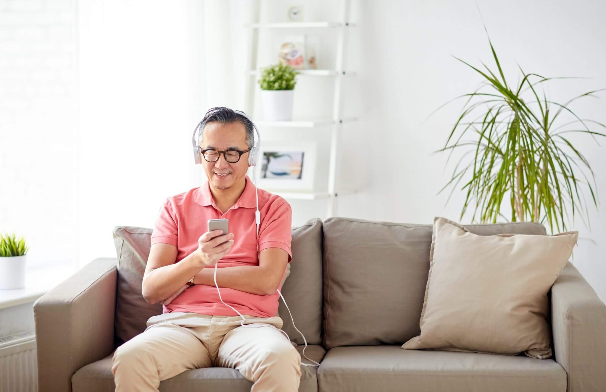 man-with-smartphone-and-headphones-at-home-PTRSEAS-2048x1326